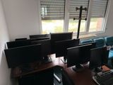 four computer monitors on a desk in a room