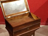 a small wooden desk with a mirror on top of it