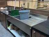 une cuisine équipée d'un évier et d'un plan de travail sur lequel est posé un saladier