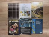 several books on a wooden floor with a plane in the background