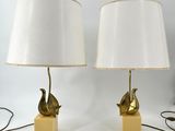 paire de lampes en forme d'oiseaux en laiton, avec des abat-jours blancs, montées sur des socles en bois