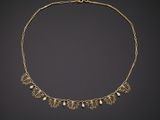 a gold necklace with pearls and leaves
