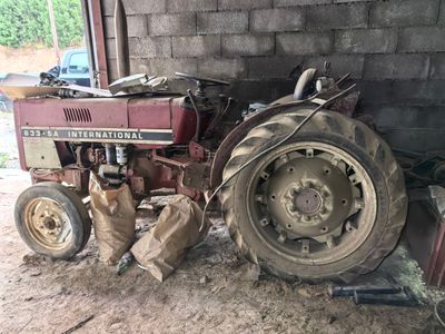 a red tractor that is parked in a barn