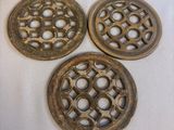 three antique cast iron grates with holes and holes on them