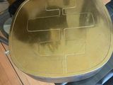 a glass table with a gold plate on top of it