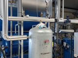 a large tank of water next to a bunch of pipes