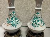 une paire de vases blancs et dorés ornés de fleurs vertes