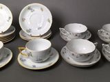 many cups and saucers that are sitting on the table