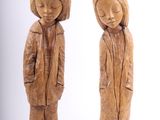 une paire de figurines en bois sculpté représentant un garçon et une fille debout l'un à côté de l'autre