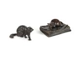 two figurines of animals that are sitting on a book