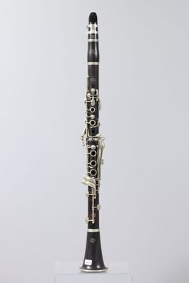 a close up of a clarinet on a stand against a white background