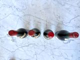 three bottles of wine are lined up on a marble surface