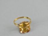 a close up of a gold ring on a white surface