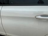 a white car that has a broken door handle on the side of it