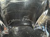 a person holding a clear glass vase with writing on it