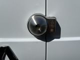 a close up of a metal door handle on a white van