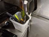 a bucket of utensils sitting on the counter in the kitchen