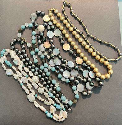 a lot of necklaces that are on display on a table
