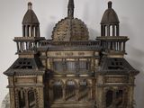 statue of a building made out of wood with a clock on top