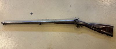 un vieux fusil sur le mur d'une pièce