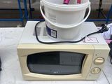 a microwave sitting on top of a table with a bucket of food in it