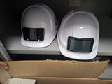 deux casques de chantier blancs posés sur une boîte en carton