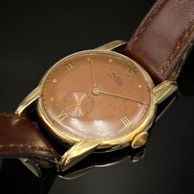 gros plan d'une montre-bracelet avec un bracelet en cuir marron