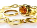 un gros plan d'un bracelet en or sur lequel est enfilée une bague