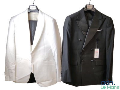 two suits hanging on a hanger next to each other