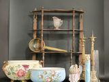 a shelf that has many different bowls and vases on it