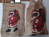 deux sacs ornés d'un Père Noël, accrochés à un mur