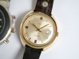two watches sitting next to each other on a white surface