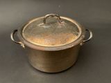 a large metal pot with a lid on a table