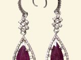 a pair of ruby and diamond earrings on a white background