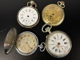 Plusieurs modèles différents de montres de poche sont exposés sur un fond noir