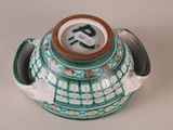 a green and white vase with a tag on it