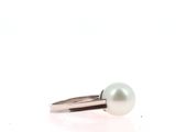 a close up of a ring with a pearl on it