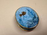 a small blue box with a gold fish on it