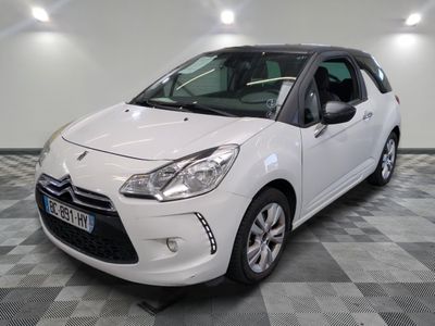 la petite voiture blanche est garée sur un carrelage à carreaux