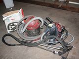 a pile of vacuum cleaners and other tools on the floor