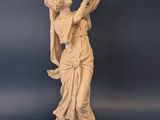 statue d'une femme tenant une harpe sur fond bleu
