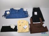 quatre paires de jeans et un t-shirt posés sur une table