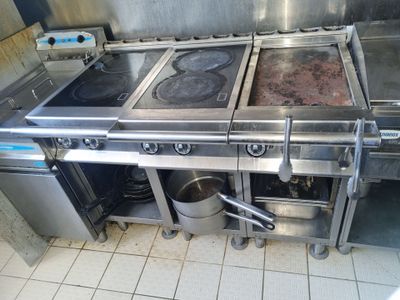 une grande cuisine avec une cuisinière et deux casseroles posées sur le plan de travail