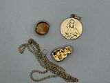 trois bijoux, dont une pièce de monnaie, un collier et un pendentif