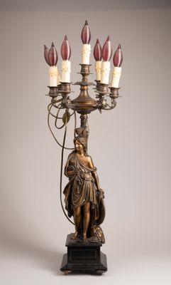 an image of a bronze statue of a woman holding a candelabra
