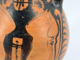a black and orange vase with a picture of a man on it