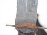 a close up of a knife on a piece of metal