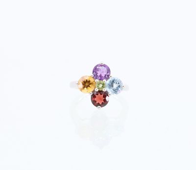 un gros plan d'une bague ornée de trois pierres de couleurs différentes