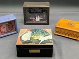 Trois petites boîtes en bois et une horloge sont posées sur une table