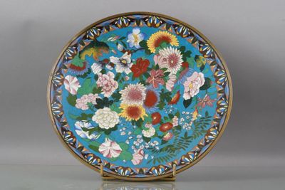 une assiette bleue décorée de fleurs et d'oiseaux
